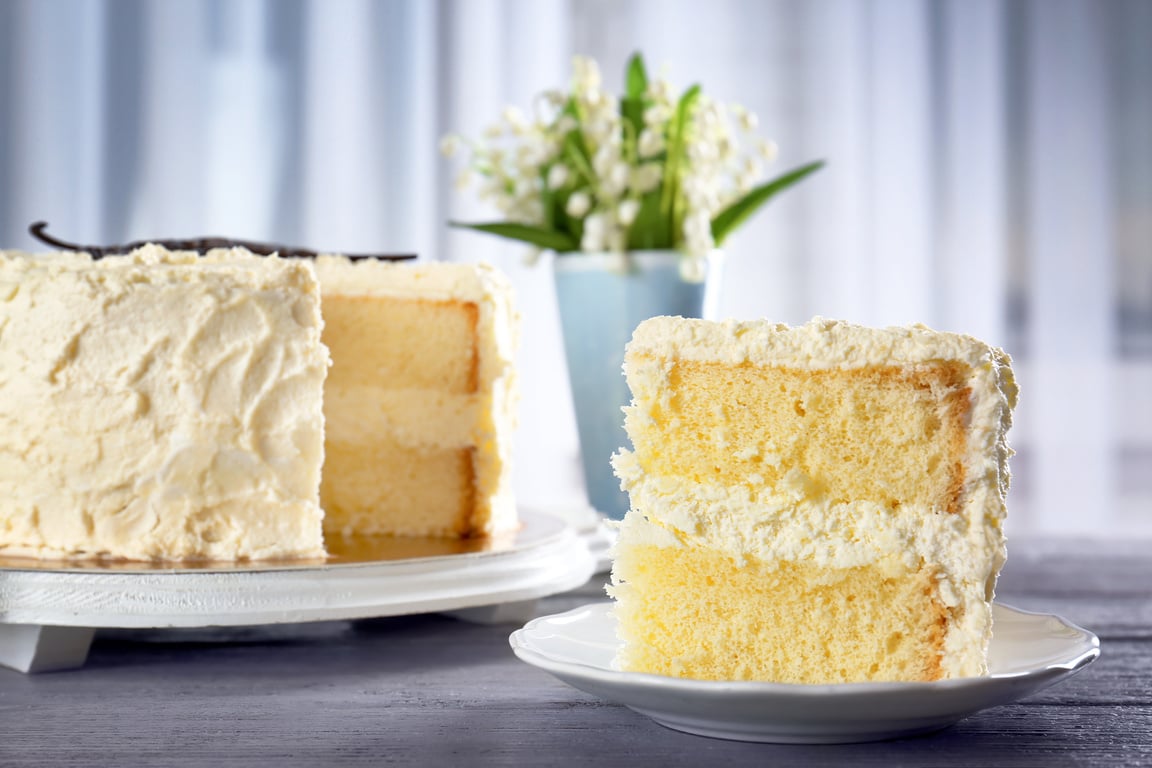 Slice of Delicious Vanilla Cake on Wooden Table